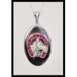 A stamped 925 pendant locket having a raised horse