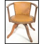 An early 20th Century industrial oak captains swivel armchair. The chair being raised on quadruped