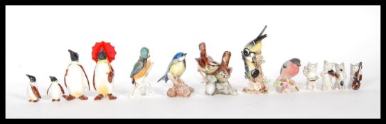 A selection of china figurines to include a group of four Beswick penguins including two large