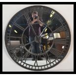 A large contemporary ebonised iron framed skeleton wall clock, mirrored backed and iron roman