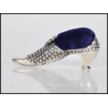 A sterling silver Victorian style pincushion in the form of a shoe having embossed decoration,