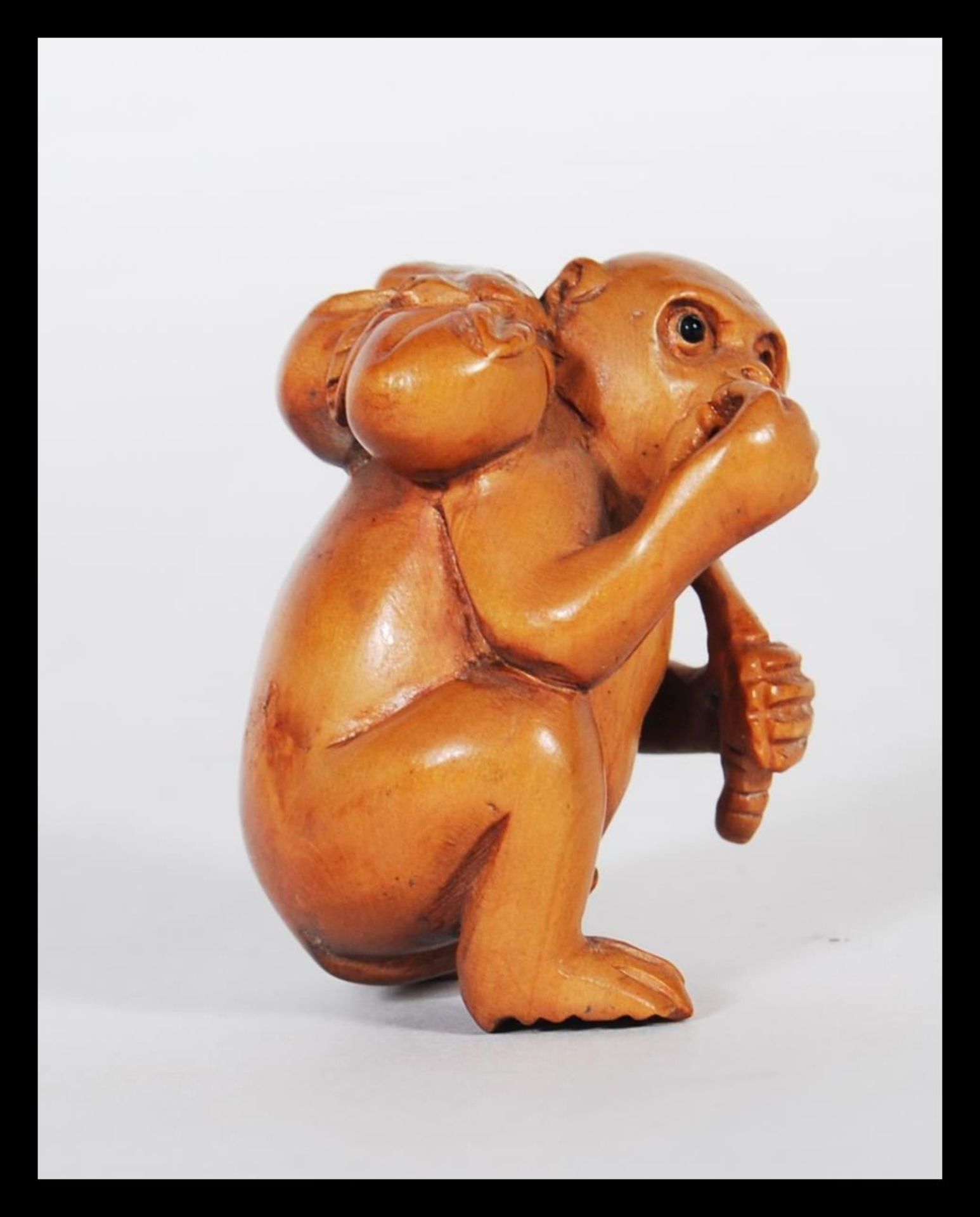 A 20th Century Japanese carved wood netsuke in the form of a monkey carrying a fruit to its back. - Bild 2 aus 7