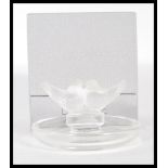 A Lalique pin dish, circular base surmounted by kissing doves, signed, within original retailers