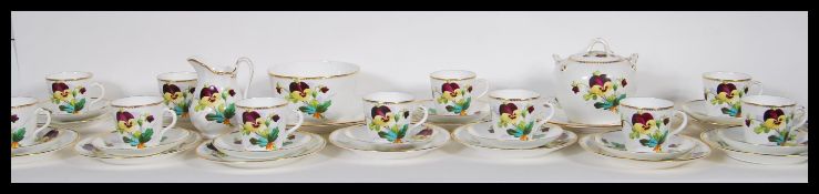 An early 20th Century hand painted china tea service having having painted pansy flowers and gilt