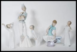 A collection of five ceramic figurines by Lladro to include a tall figurine of a lady holding