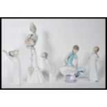 A collection of five ceramic figurines by Lladro to include a tall figurine of a lady holding