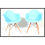 A pair of Eames style DSW chairs. The armchairs in blue. Raised on tapered legs with wirework