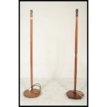 A pair of retro 20th Century teak wood standard lamps raised on terraced bases with turned