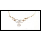 A stamped 9ct gold necklace having a snake chain and with a twisted decoration pendant set with