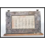 An early 20th Century Edwardian silver fronted  desk calendar, on plinth base, having rotating