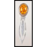 A stamped 925 silver bookmark having an amber cabochon finial. Weight 7.5g.Measures 8cm wide.