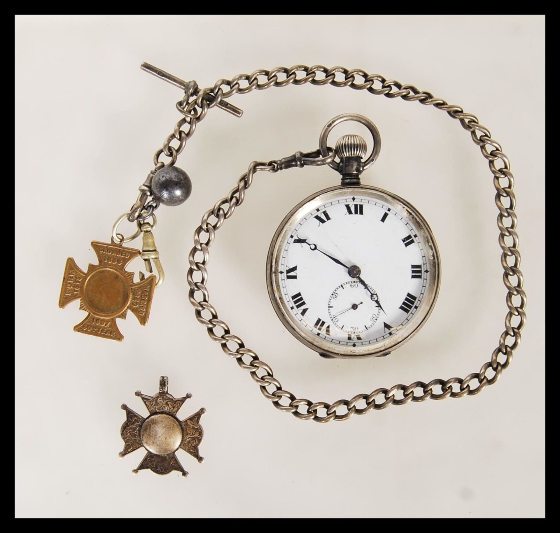 An early 20th Century silver pocket watch having a white enamelled face with roman numerals to the