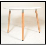 A contemporary white laminated and ash circular dining table. The table comprising of a laminated