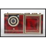 A 1950s West German "Petie" vanity camera with marbled red effect body, camera section, within
