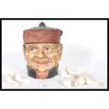 A early 20th Century Austrian ceramic tobacco jar in the form of a male head wearing a hat with