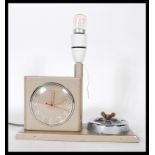 A vintage retro mid century bedside alarm clock lamp and ashtray combination, being finished in an