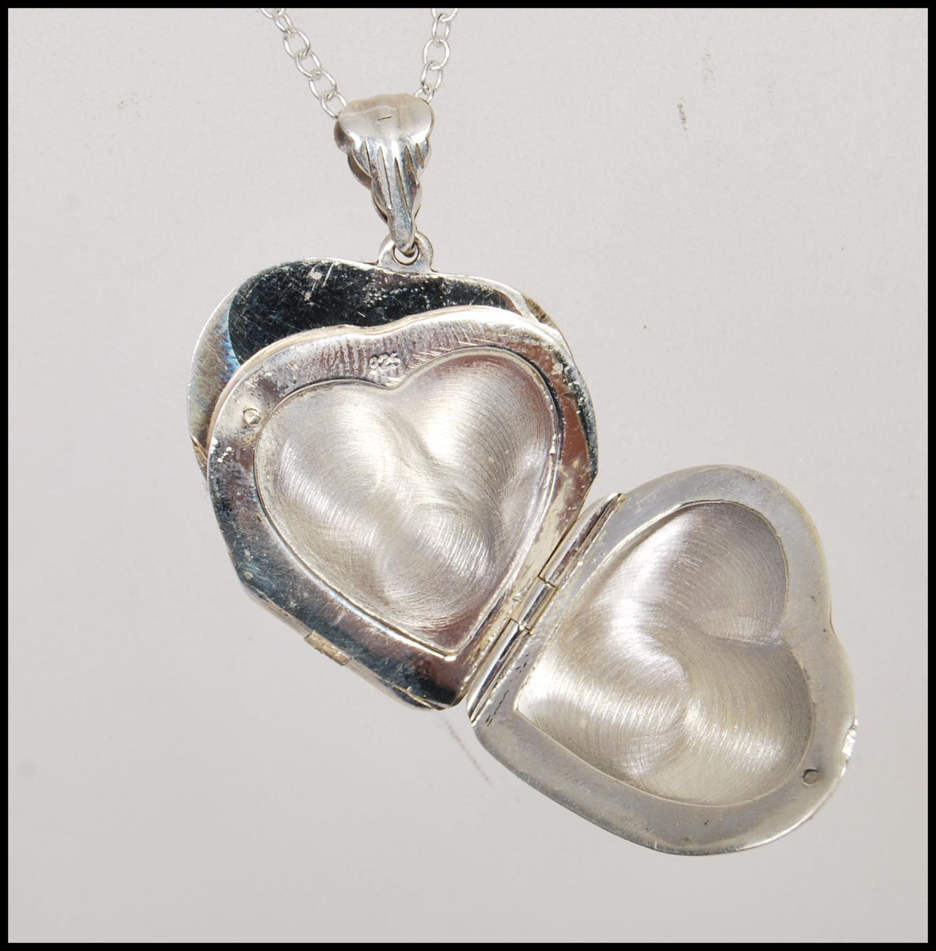 A double sided silver heart shaped locket having engraved decoration to both sides. Stamped 925 on a - Bild 3 aus 4
