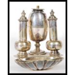 An early 20th Century silver plated oil burner consisting of a central bulbous form bottle with wick