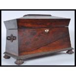 A 19th Century rosewood tea caddy of sarcophagus form having mother of pearl inlay to the lid,