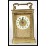 A early 20th Century brass French carriage clock having white enamel chapter ring with arabic