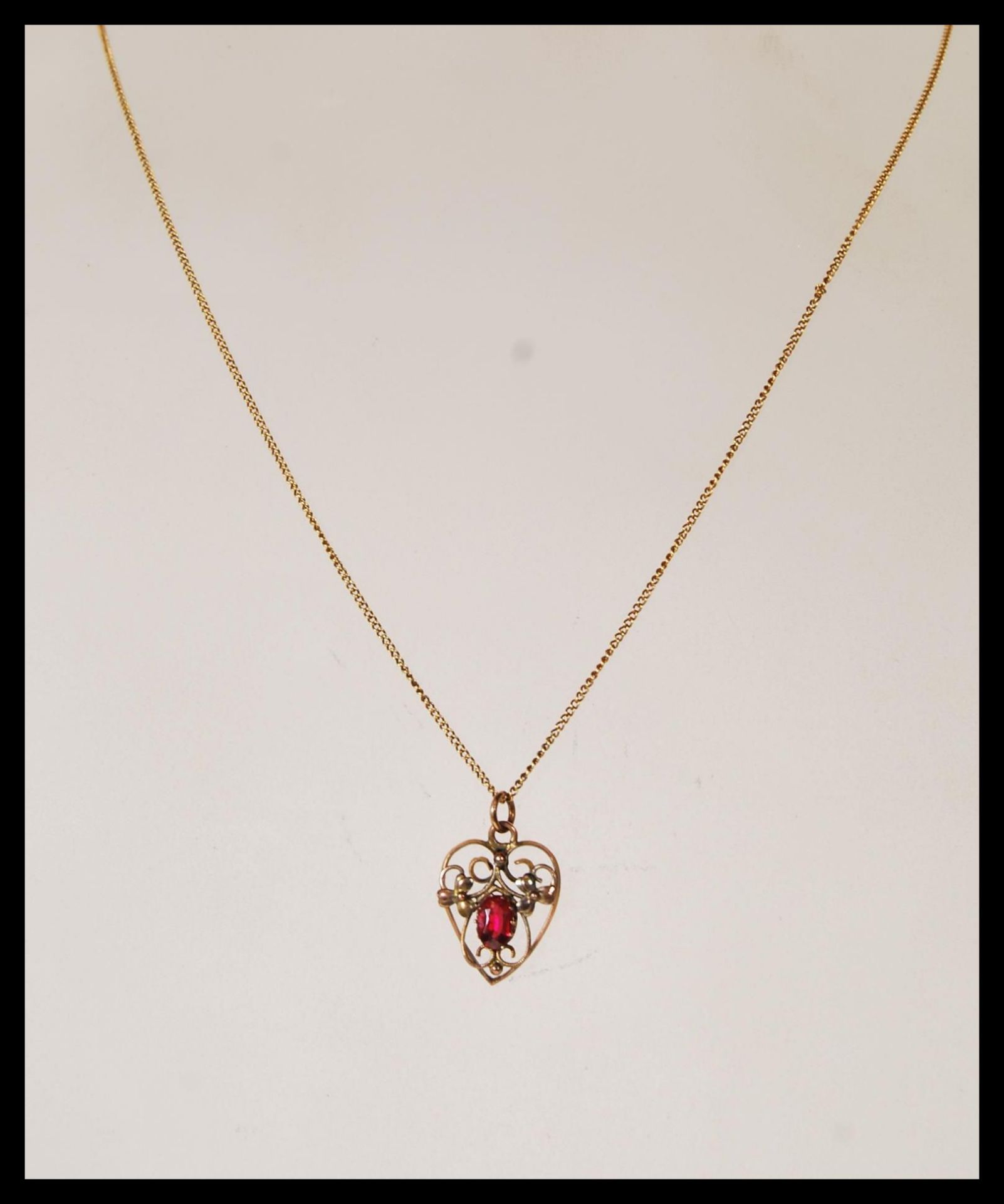A 9ct gold openwork heart shaped pendant necklace, having a red stone to centre, with floral design, - Bild 2 aus 5