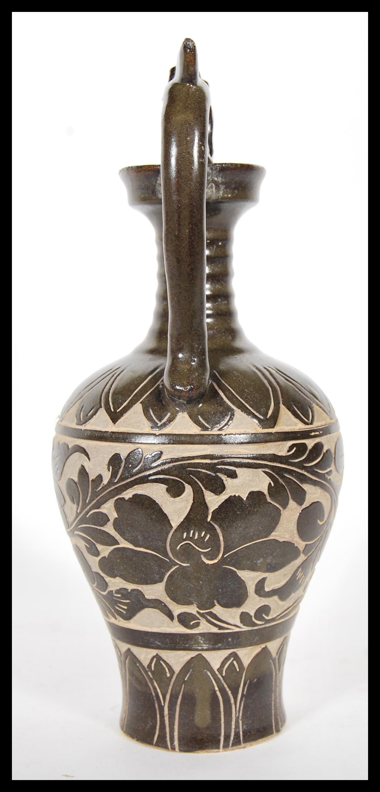 A Chinese stoneware vase / urn having shaped twin handles with floral relief decoration to the - Image 2 of 6