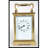 A 20th Century brass cased four pane carriage clock having a white enamelled face with roman