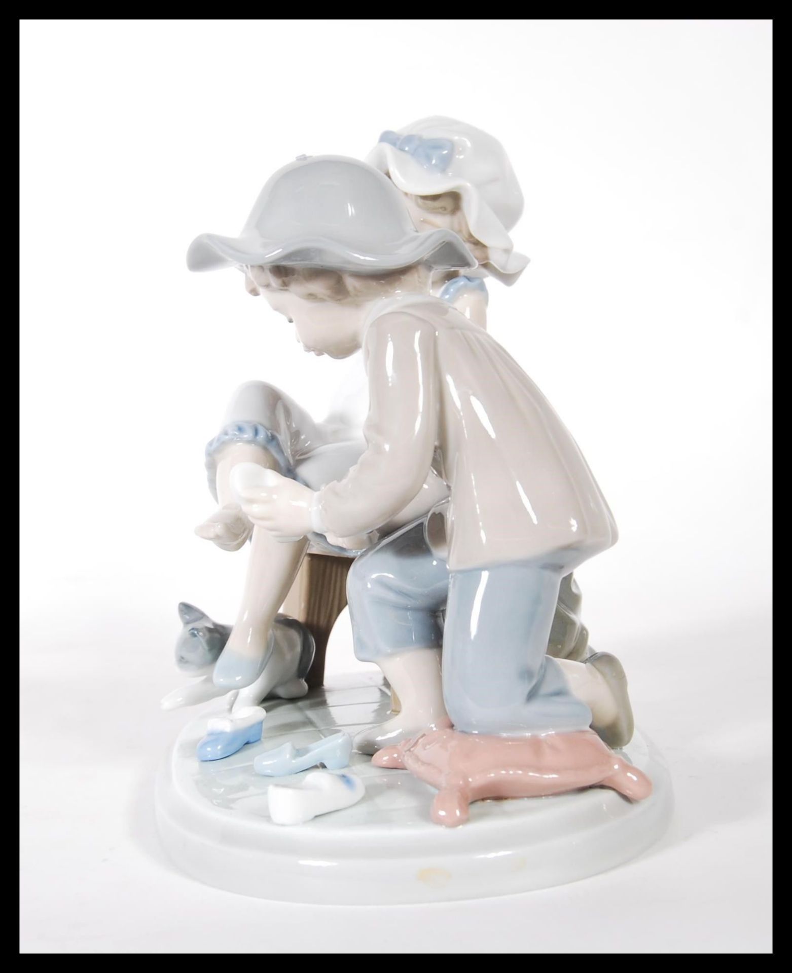 A Lladro ceramic figure group titled ' Try this One ', (5361) of a young girl trying on a shoe. - Bild 4 aus 6