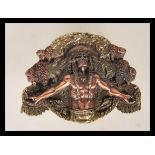 A cast metal belt buckle having raised decoration of a Native American having outstretched arms