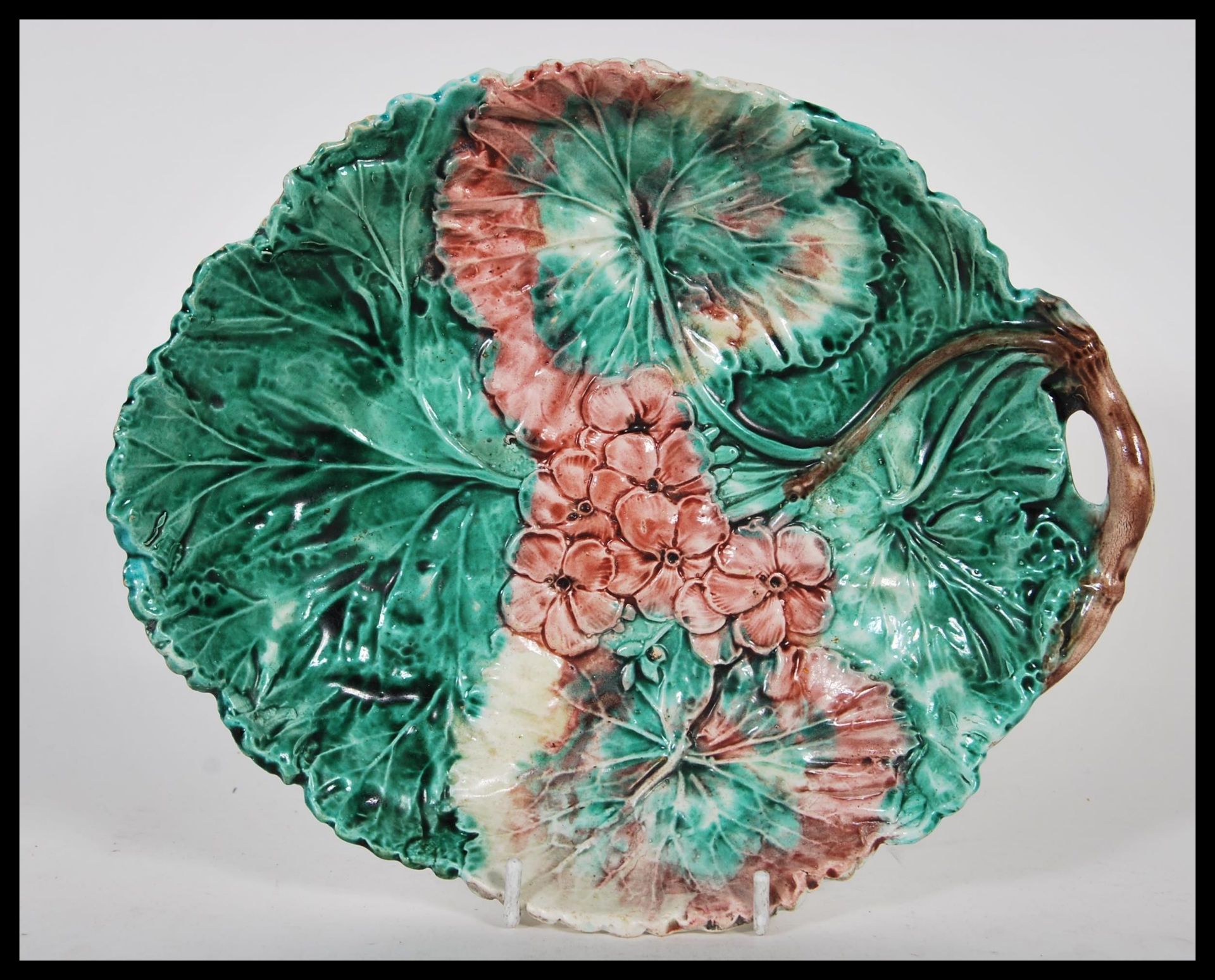 A 19th Century Victorian majolica flower plate, decorated with brightly coloured flowers on a