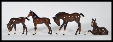 A group of four Royal Doulton ceramic figurines modelled as horses / fouls in various positions /