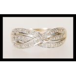 A stamped 375 9ct gold crossover ring set with white accent stones. Weight 2.5g. Size Q.5.
