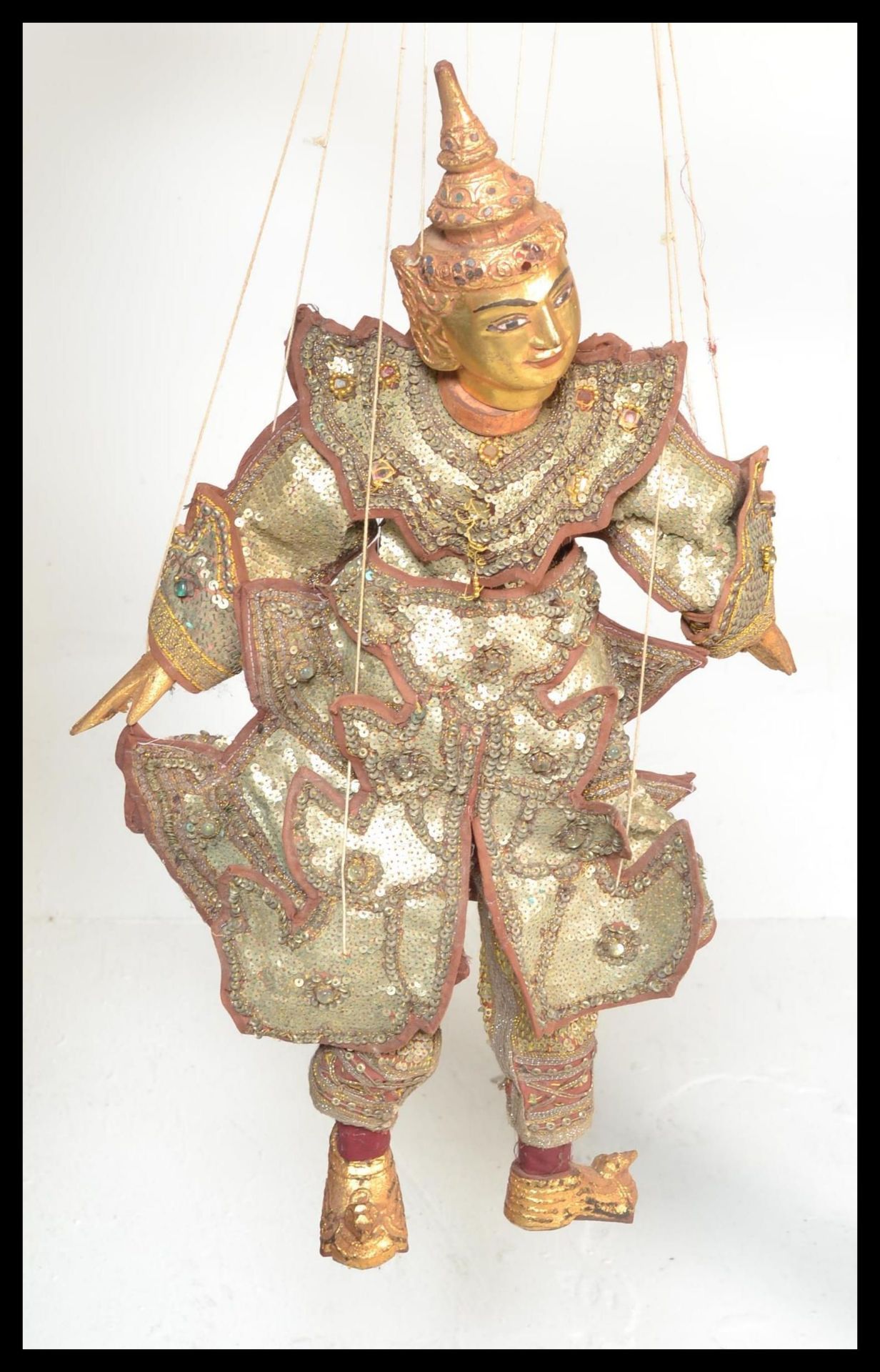 A Vintage Antique Thai string wooden puppet, wearing sequin garments having gilt finish to hands,