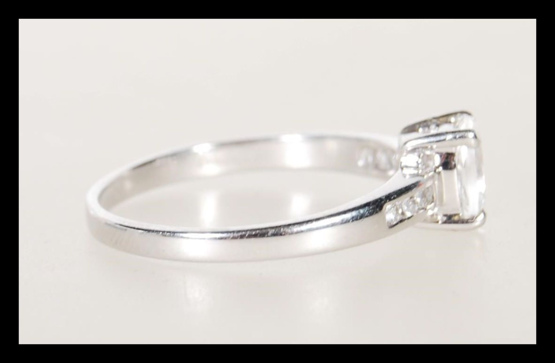 A hallmarked 9ct white gold ladies ring prong set with a oval cut white stone having accent stones - Bild 2 aus 5