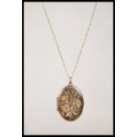 A stamped 375 9 ct gold necklace having a fine Figaro chain (stamped 375) with a locket pendant