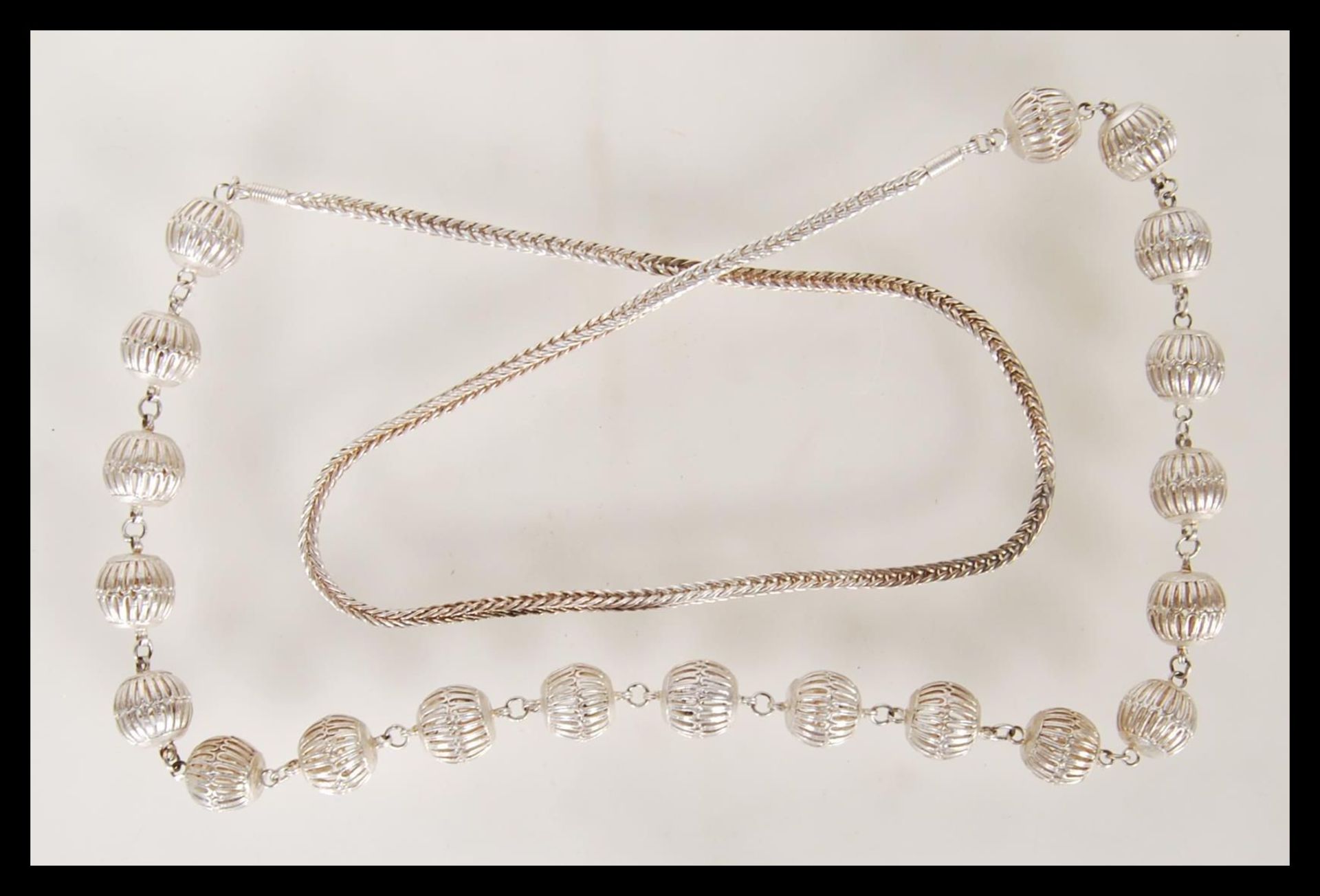 A 20th Century ethnic style silver necklace having a series of pierced decoration beads on a snake