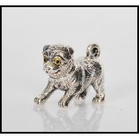 A sterling silver figure of a dog have coloured eyes. Stamped sterling 925 to base. Weighs 13.9g.