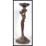 A 20th century Art Nouveau bronze effect table lamp in the form of a maiden holding a flower stem.