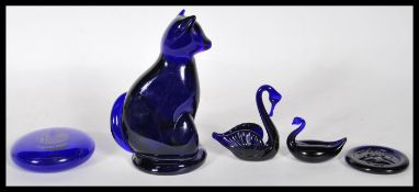 A collection of Bristol Blue glass items to include a cat figurine with a curled tail signed B