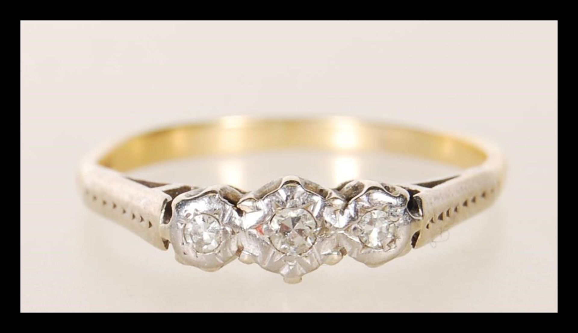 An early 20th Century stamped 18ct gold ring having three illusion set diamonds to the head.