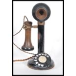 A vintage early 20th Century stick telephone of brass construction having bakelite mouth and