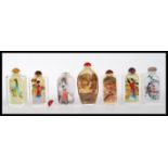 A group of seven 20th Century Chinese glass snuff bottles having reverse decorated scenes to the