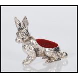 A sterling silver pincushion in the form of a rabbit, having red baize pin cushion to top. Stamped