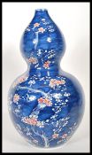 A large bulbous 20th Century Chinese blue and white double gourd vase in the Prunus pattern,