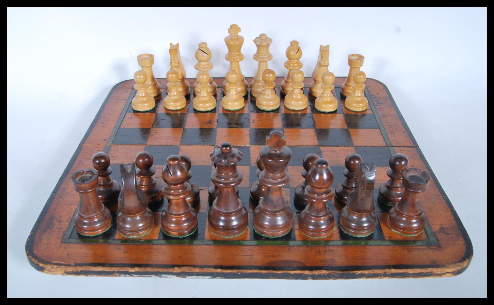 A late 19th/ early 20th Century pine chess board having green border and ebony squares, together