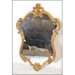 A 20th Century Rococo gilt framed wall mirror,  of cartouche form in the Rococo style.Measures 100cm