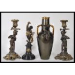 A 20th Century garniture of mantelpiece ornaments to include a pair of cast metal figural