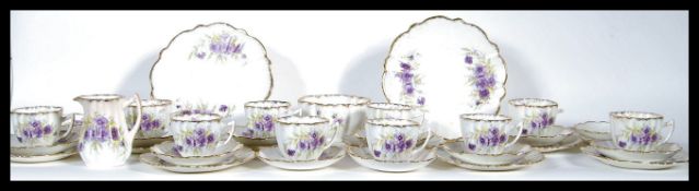 A 19th Century bone China Staffordshire part tea service, decorated with violet coloured flowers and