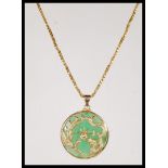 A gold on silver stamped 925 Chinese Jade pendant of circular form, having Dragon and Phoenix