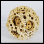 An early 20th Century carved ivory Chinese puzzle ball having six concentric balls, being carved
